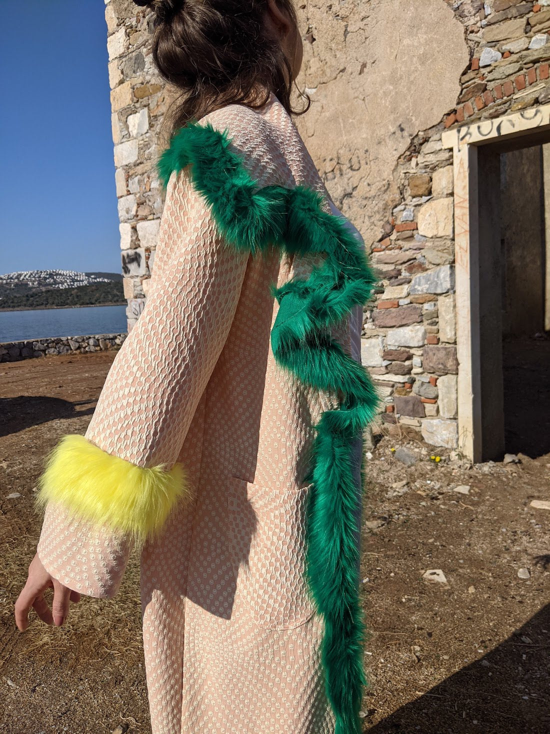 Side view of handmade pink kimono jacket highlighting faux-fur collar trim and neon yellow faux-fur cuffs.